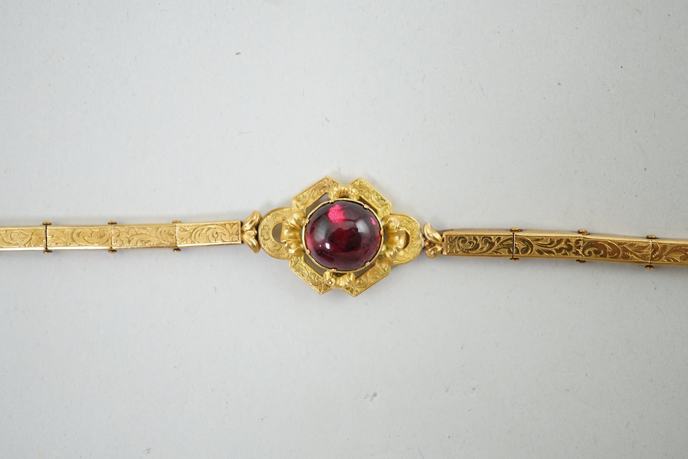 An early 19th century engraved gold and cabochon garnet set mourning bracelet